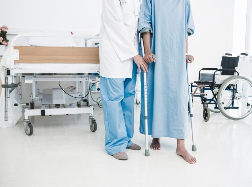 Patient walking on crutches assisted by nurse