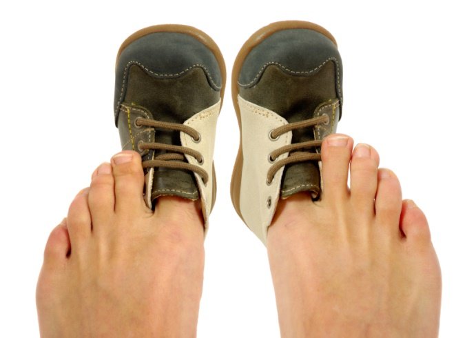 Baby shoes on adult's big toe