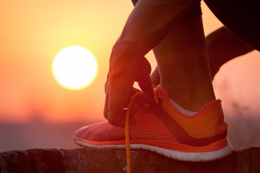 Someone tying sneaker while sun is setting